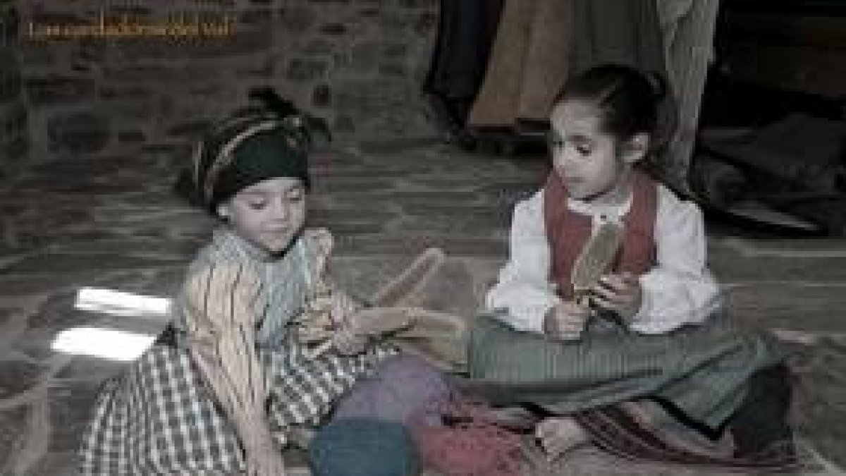 Dos niñas en una estampa típica de principios de siglo, cardando la lana en el Val de San Lorenzo