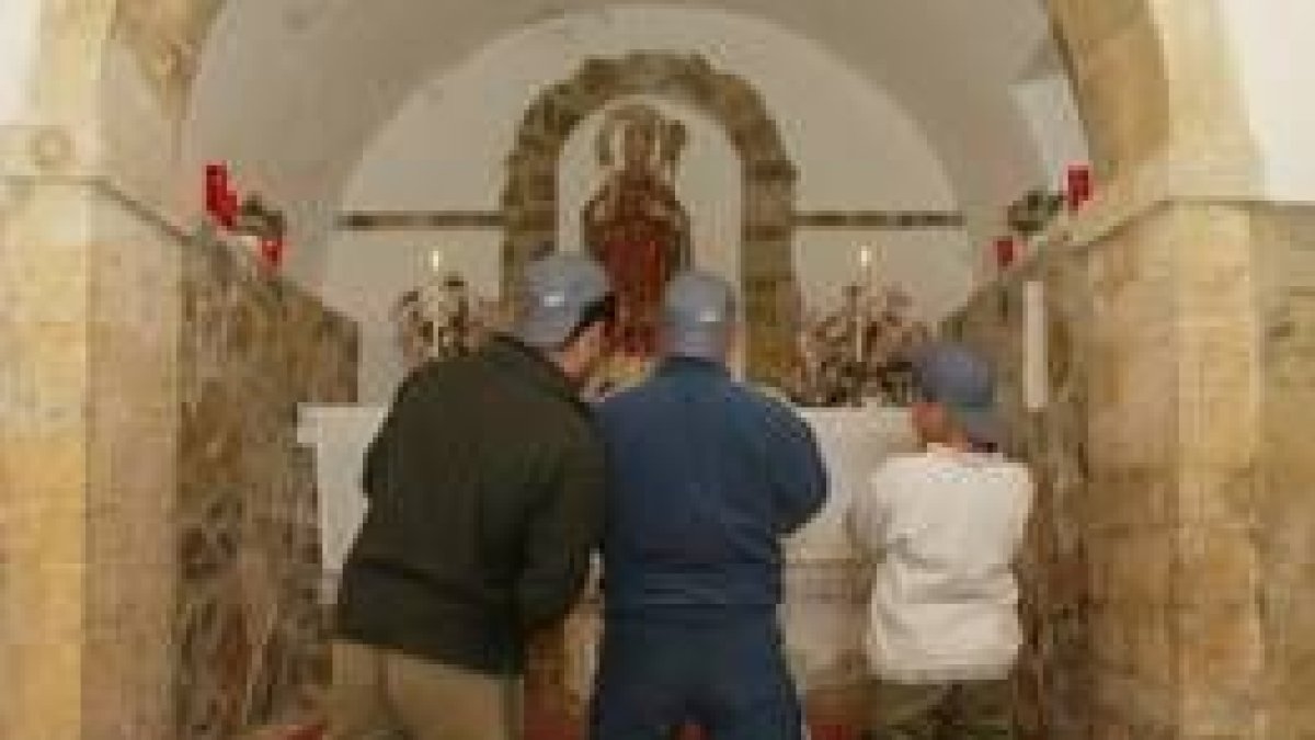 Imagen de tres niños rezando en una ermita de la Valdorria