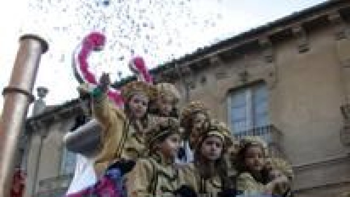 Una niña arroja confetis desde una de las carrozas que formaban el desfile infantil de este año
