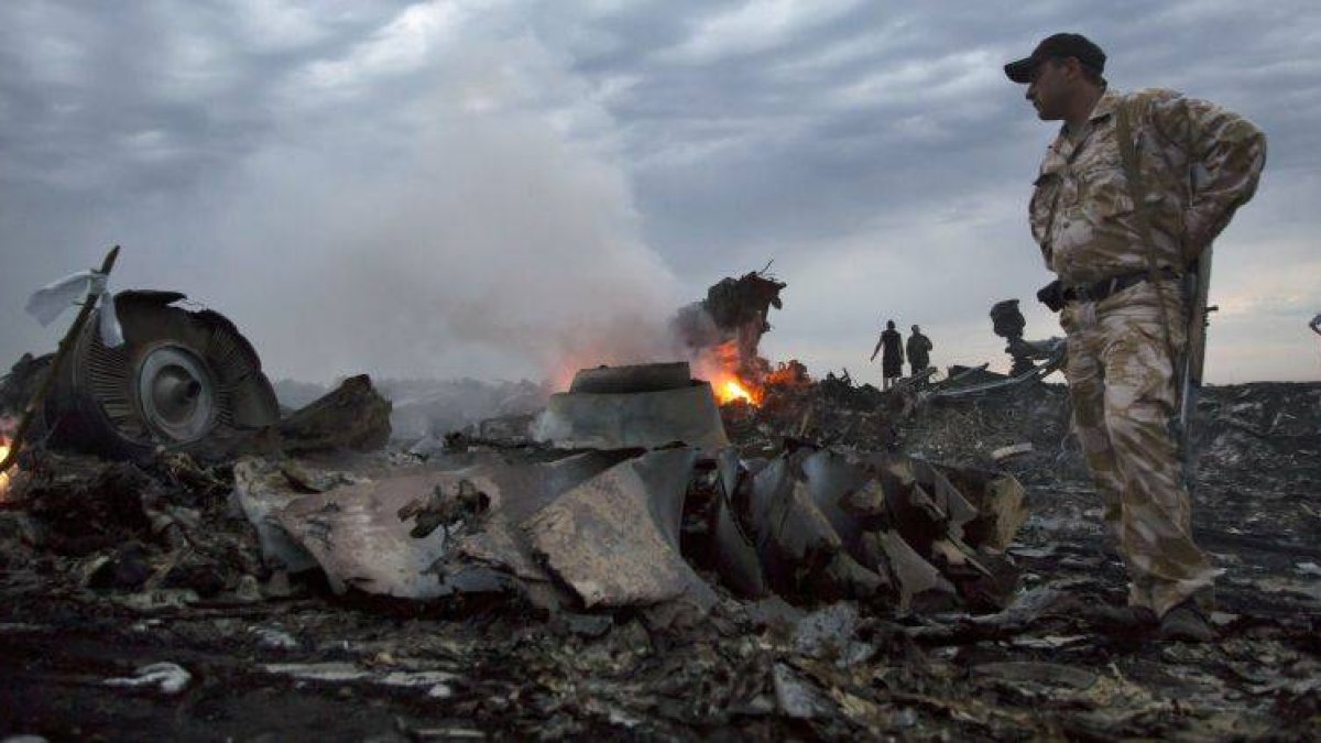 Un miliciano observa parte de los restos del avión de Malaysia Airlanes.