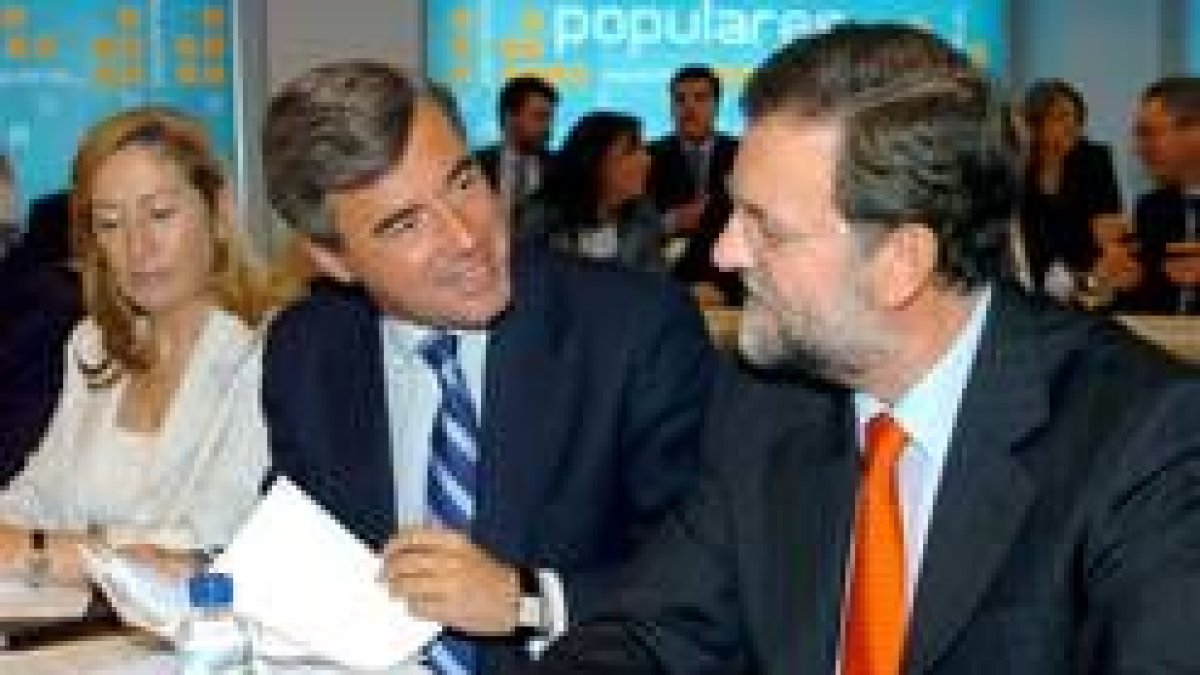 Ángel Acebes conversa con Mariano Rajoy en presencia de Ana Pastor, durante la reunión de ayer