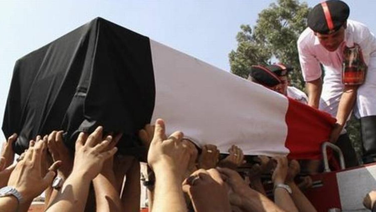 Un féretro con los restos de un policía muerto en los disturbios del miércoles es trasladado por sus compañeros, durante los funerales celebrados este jueves en El Cairo.