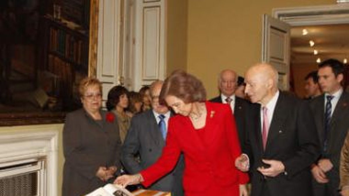 La Reina Doña Sofía observa el atlas durante la presentación