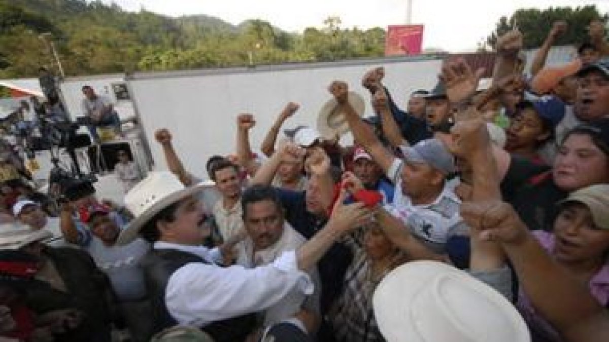 El presidente depuesto, Manuel Zelaya, saluda a sus seguidores en la frontera.