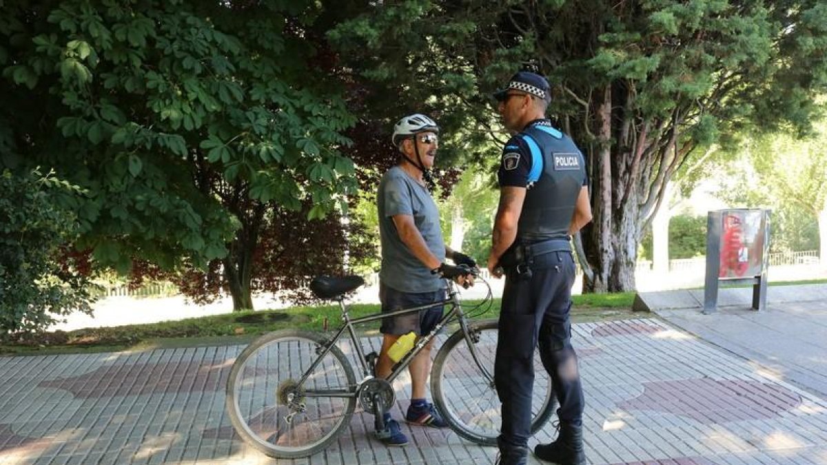 Un agente informa a un ciclista de la nueva ordenanza que prohíbe circular por las aceras.