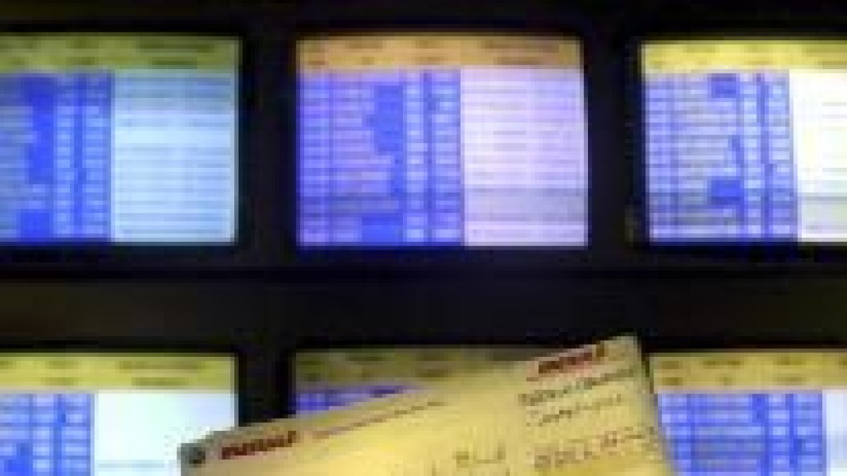 Un pasajero comprueba su vuelo en los paneles de información del aeropuerto de Barajas