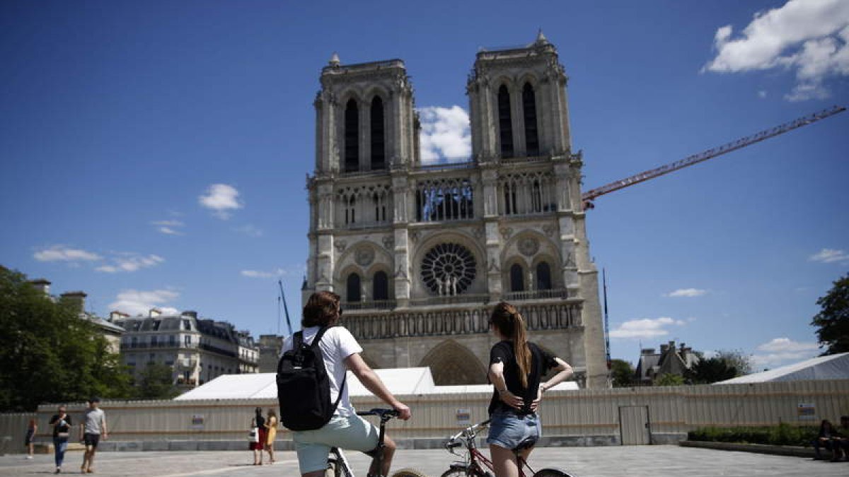Dos jóvenes ante la catedral de Notre Dame este verano. YOAN VALAT
