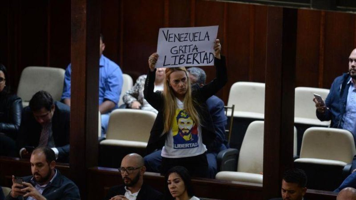 La activista Lilian Tintori, esposa del arrestado opositor venezolano Leopoldo López, muestra una pancarta contra Maduro en la Asamblea Nacional de Venezuela.