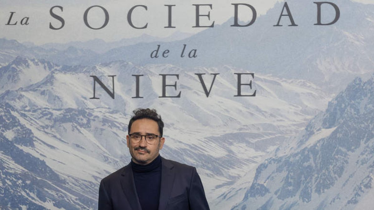 El director de ‘La sociedad de la nieve’, Juan Antonio Bayona, ante el cartel de la película. JAVIER LIZÓN