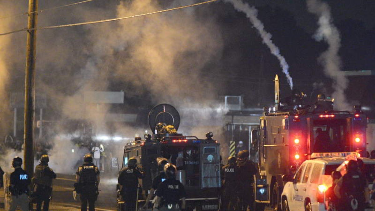 La policía de Ferguson se enfrenta a los manifestantes durante la noche del sábado.