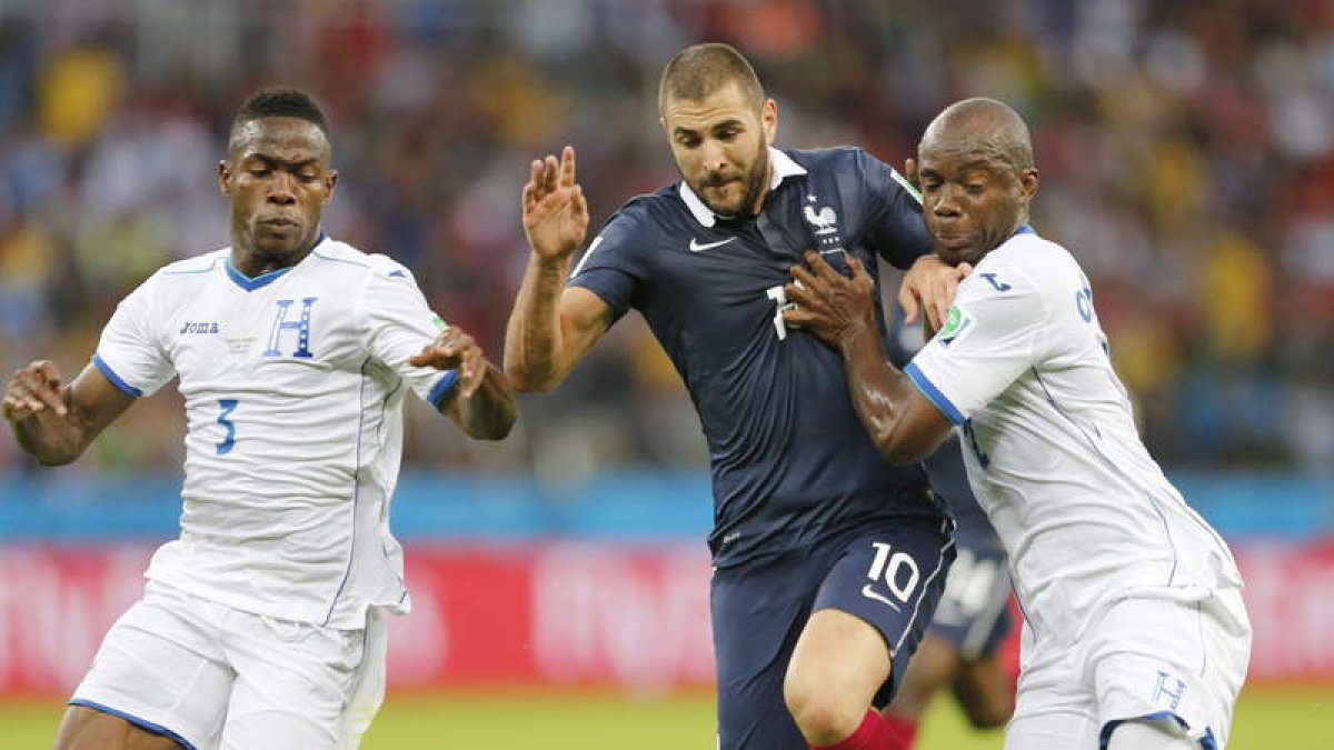 Benzema intenta escaparse de dos defensores. El delantero galo fue letal frente a Honduras.