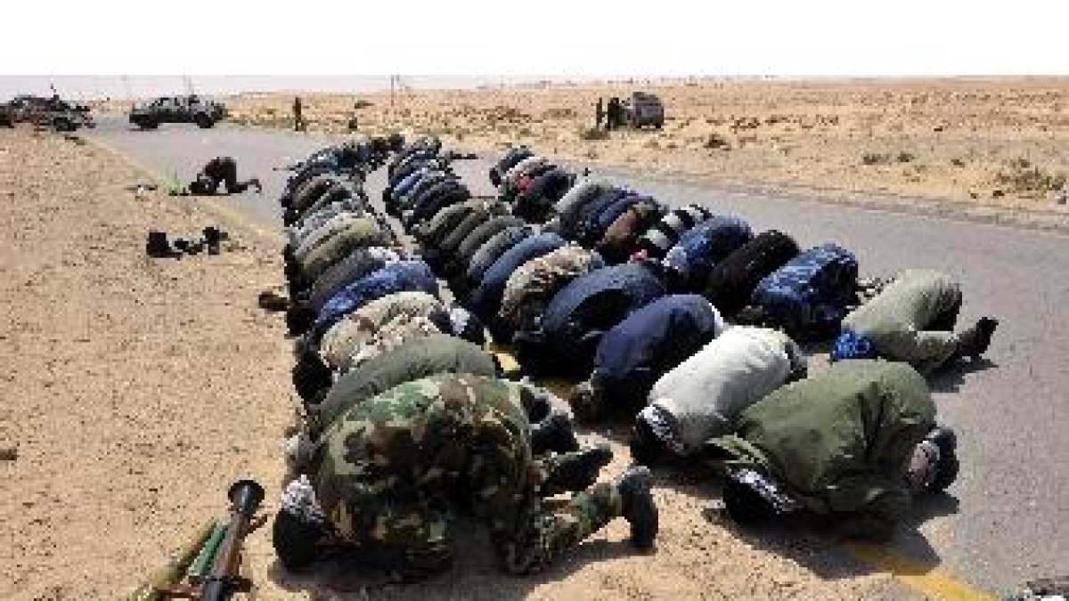 Los rebeldes libios rezan antes de combatir contra las fuerzas del gobierno de Gadafi, ayer.