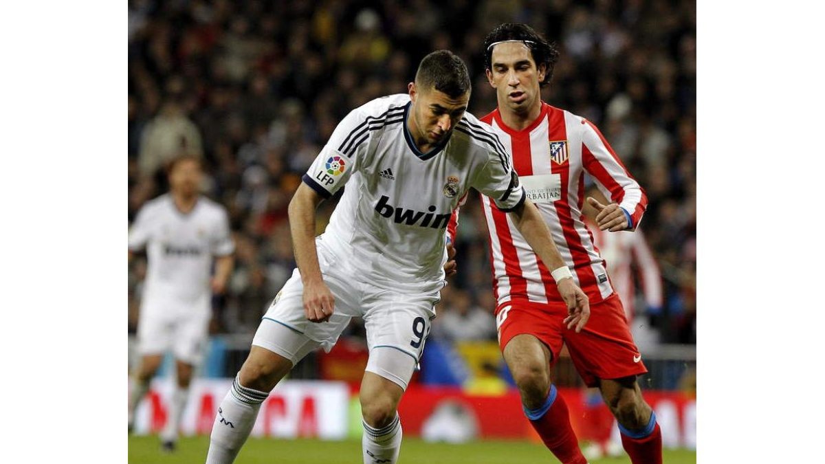 Karim Benzemá protege el balón ante el atlético Arda Turan.