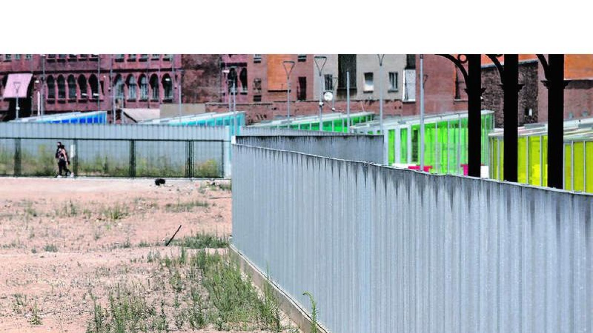 La valla que pone la linde a las dos ciudades que dejó en superficie la integración del tren. FERNANDO OTERO