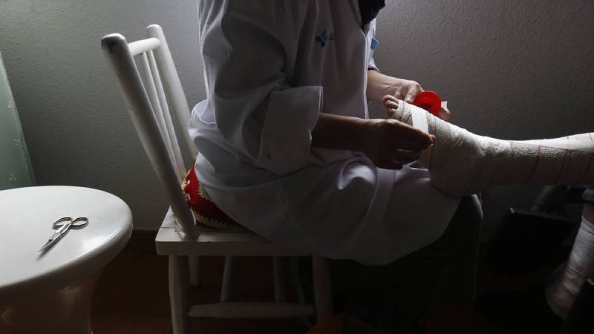 Una enfermera hace una cura en casa de un paciente