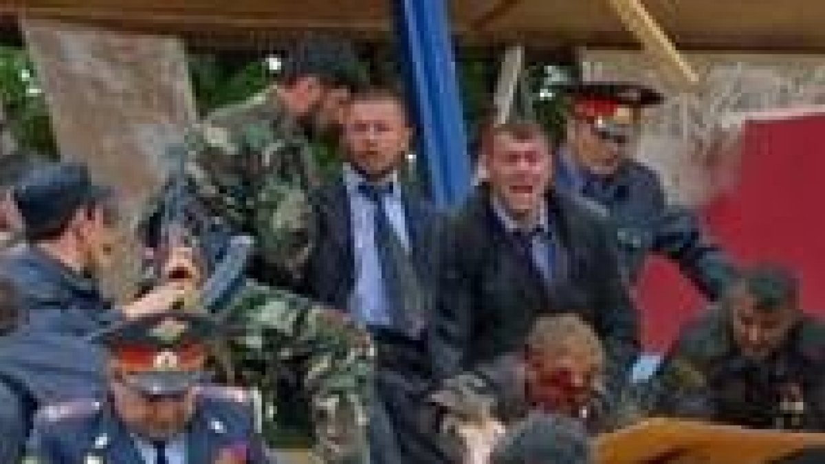 El presidente checheno, Ahmad Kadírov, es asistido por sus hombres nada más producirse el atentado
