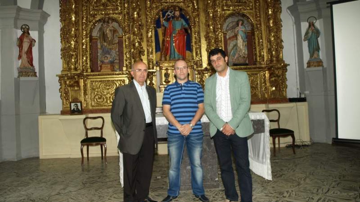 Avelino García, Jorge Martínez y Marcos Cachaldora con el retablo de San Andrés restaurado.