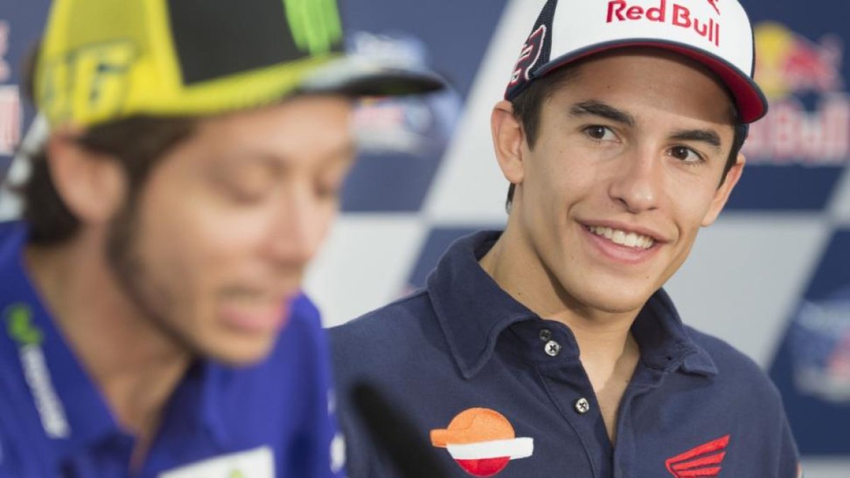 Marc Márquez mira y sonríe ante las palabras de Valentino Rossi.