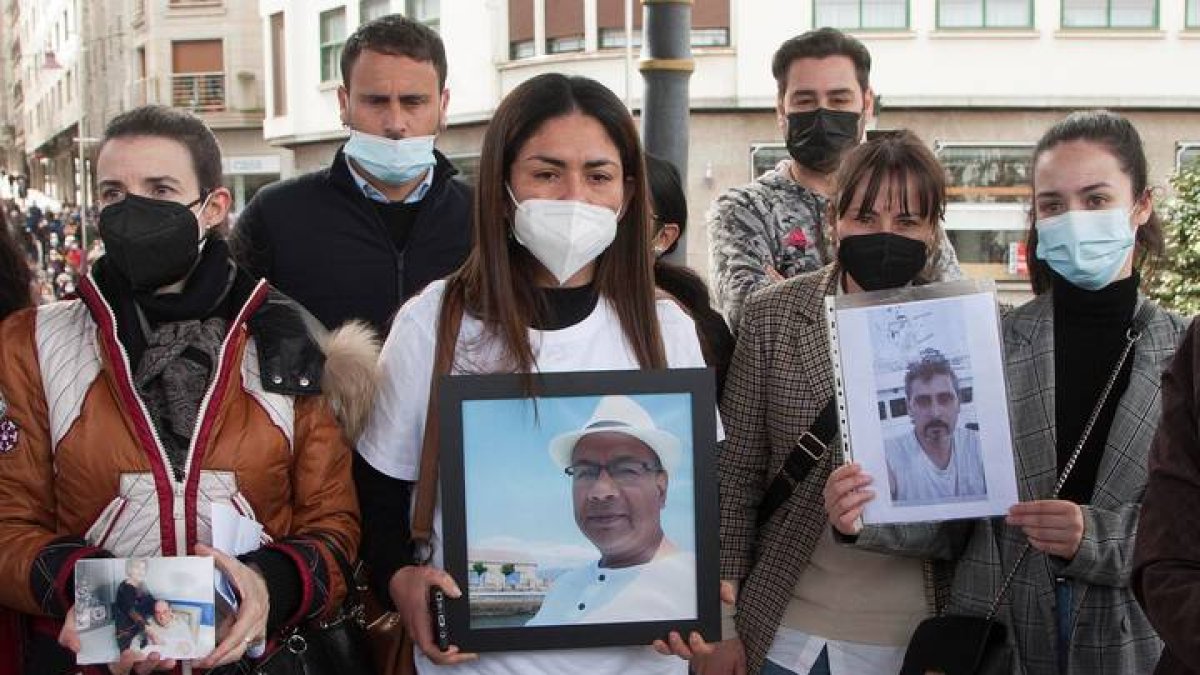 Familiares muestran retratos de varios de los miembros de la tripulación durante una multitudinaria protesta para lograr que se retome la búsqueda de los 12 marineros desaparecidos en el naufragio del Villa de Pitanxo, este domingo en el municipio pontevedrés de Marín. SALVADOR SAS