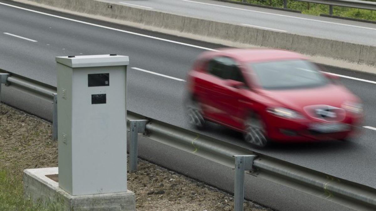 Un coche pasa junto a un radar de control de velocidad.