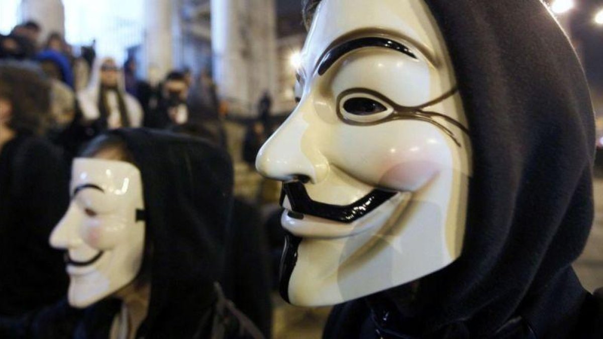 Manifestantes protestan en Bruselas con máscaras aludiendo a Anonymous.