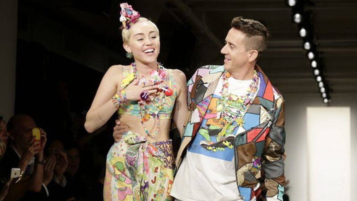 El diseñador estadounidense Jeremy Scott camina por la pasarela con la cantante estadounidense Miley Cyrus, tras presentar sus creaciones durante la semana de la moda de Nueva York.