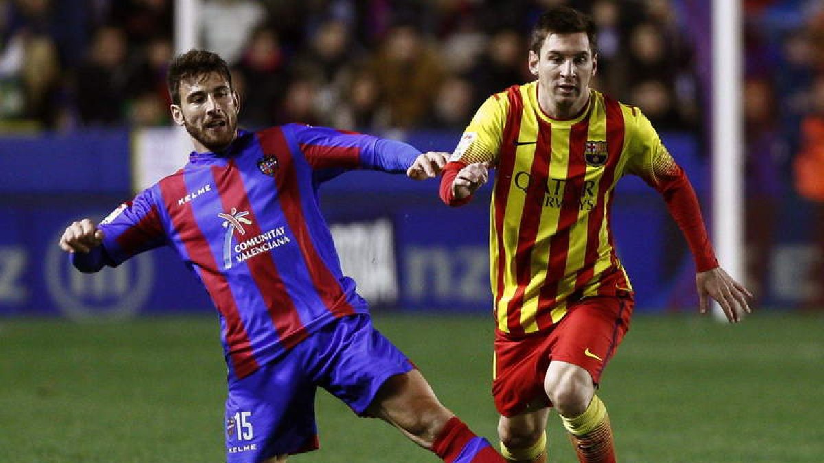 Nikos Karampelas le gana el balón al delantero argentino del Barcelona Lionel Messi.