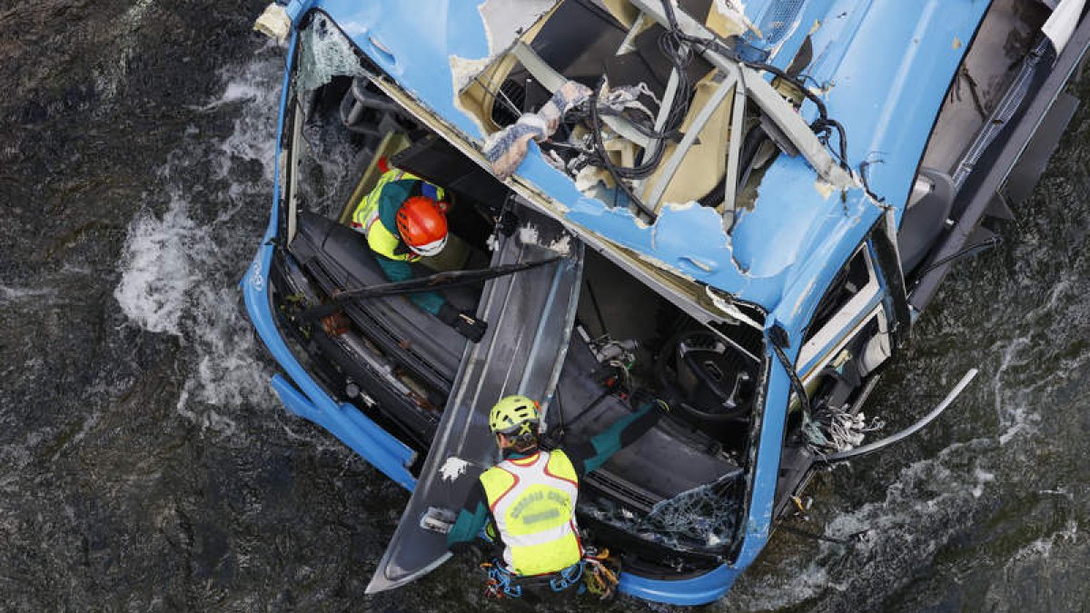 Agentes de la Guardia Civil inspeccionan el autobús que se precipitó al río Lérez. LAVANDEIRA JR