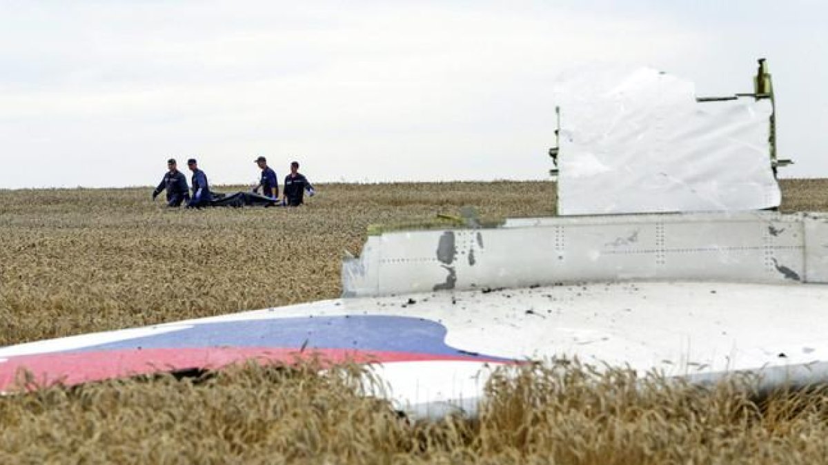 Varias personas transportan un cadáver en una camilla en medio de los destrozos de un Boeing 777, vuelo MH17 de Malaysia Airlines, derribado cerca de Donetsk (Ucrania).