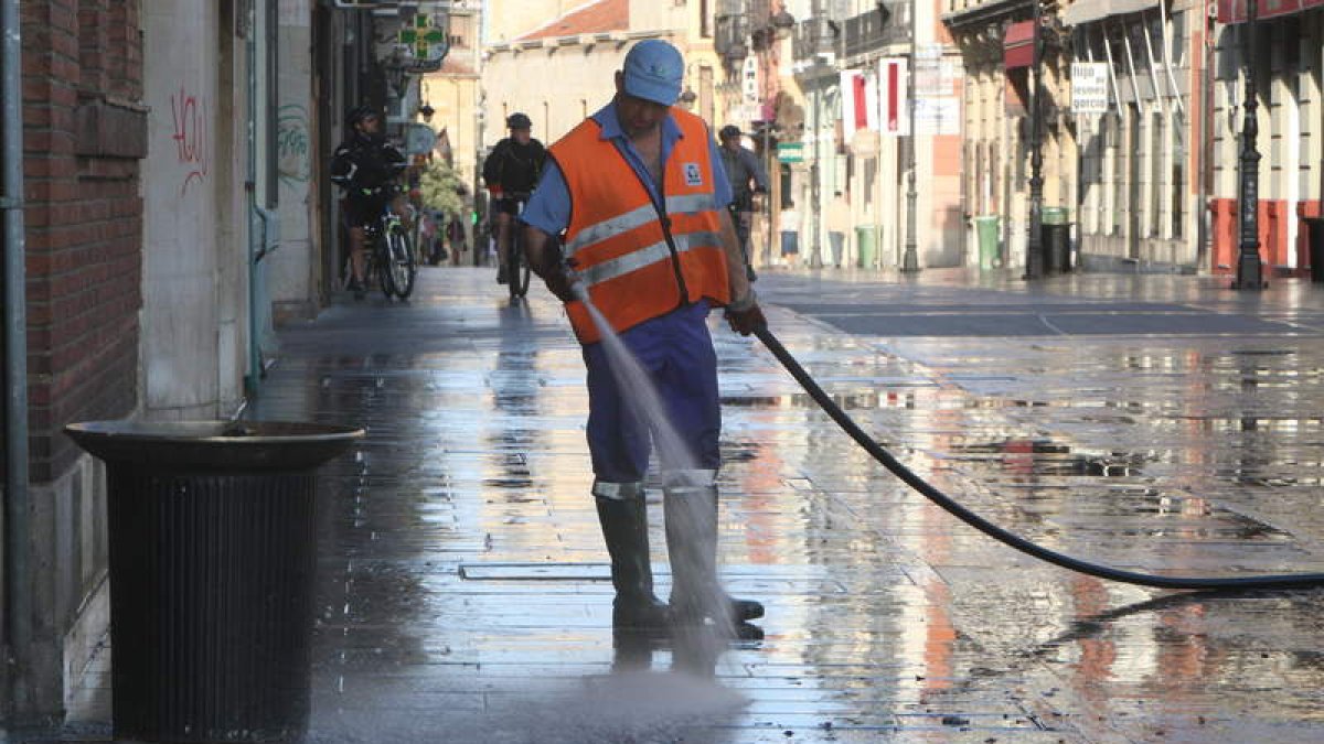 Empleado del Ayuntamiento limpiando las calles mediante baldeo manual. NORBERTO