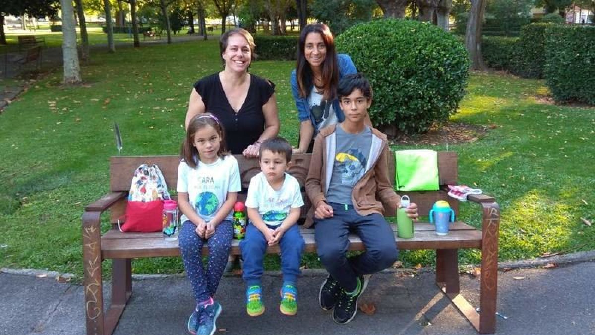 Irene y Lucía con sus hijos en el parque. Son dos de las seis familias involucradas en el proyecto en el colegio Quevedo. En el banco despliegan  su 'arsenal' contra la crisis climática: bolsas, servilletas de telas y botellas reutilizables