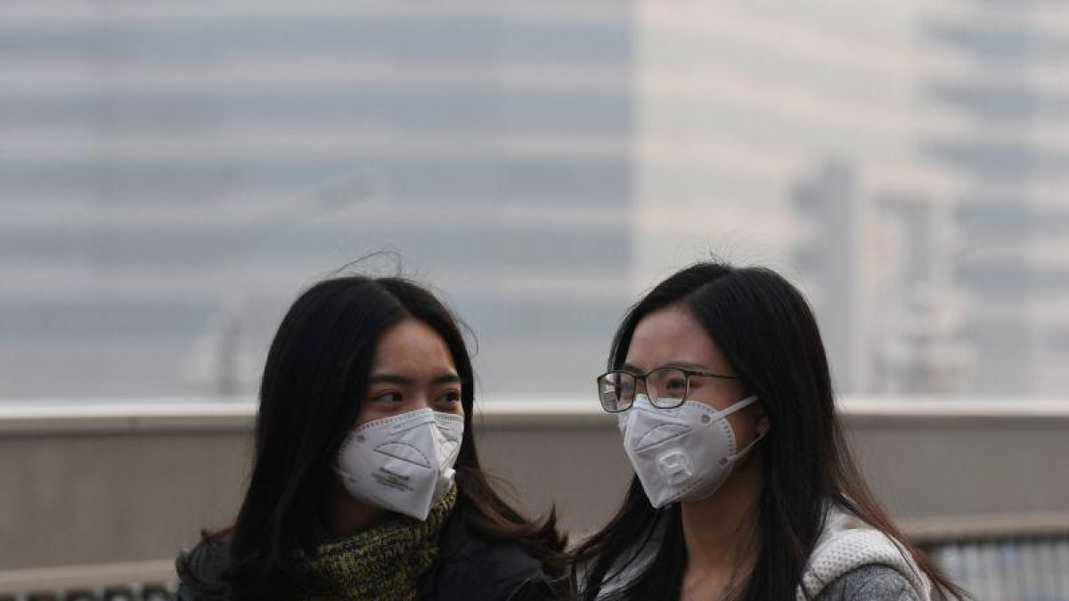 Dos chicas se protegen de la contaminación en Pekín el pasado lunes.