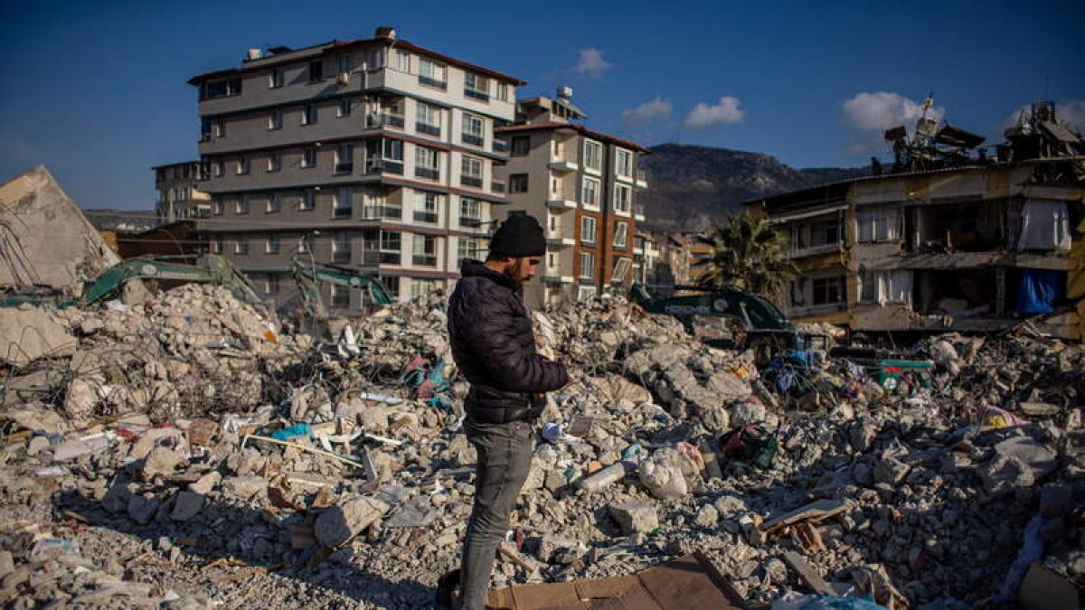 Un hombre reza en Hatay sobre los escombros de un edificio derrumbado por el terremoto. MARTIN DIVISEK