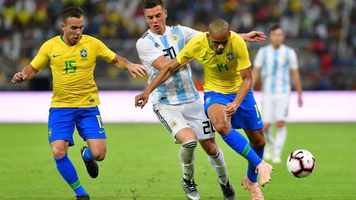 Arthur, a la izquierda, mientras Lo Celso y Fabinho pelean por un balón.