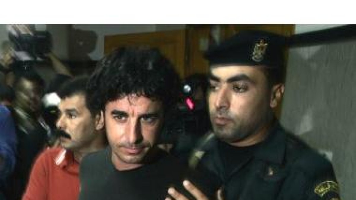 Morenatti, acompañado por un policía palestino, tras ser liberado de su secuestro en Gaza en el 2006