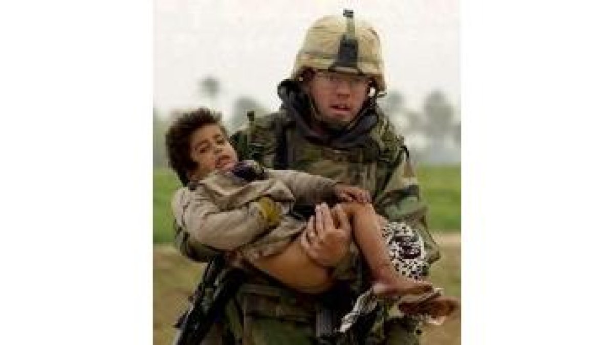 Un soldado norteamericano traslada a un niño iraquí herido en Faisaliya