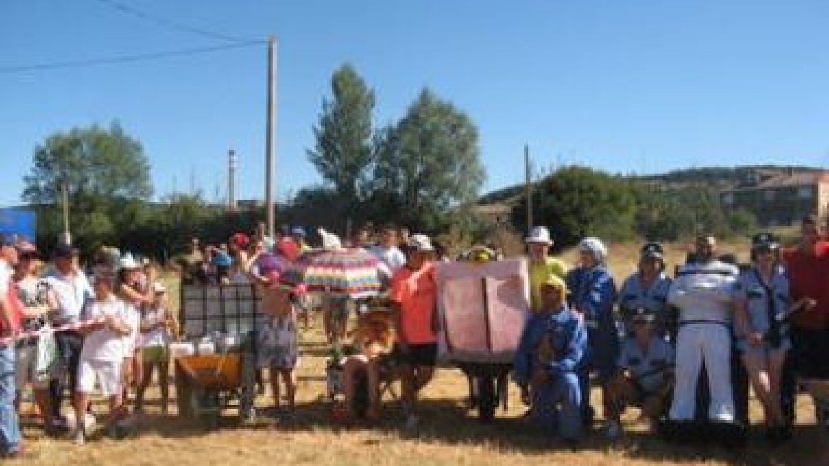 La imagen muestra la salida de los participantes de la carrera de carretillos en Llanos.