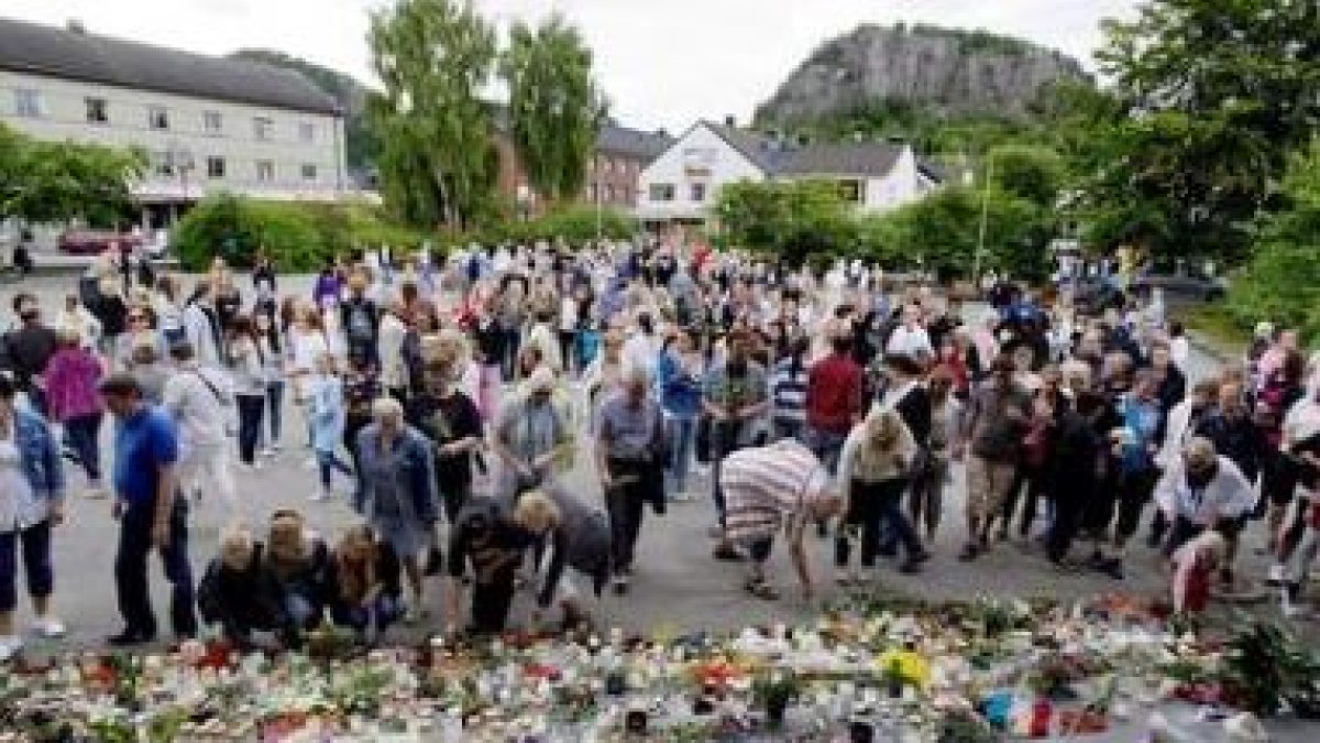 Varias personas colocan velas y flores en Namsos, Noruega.