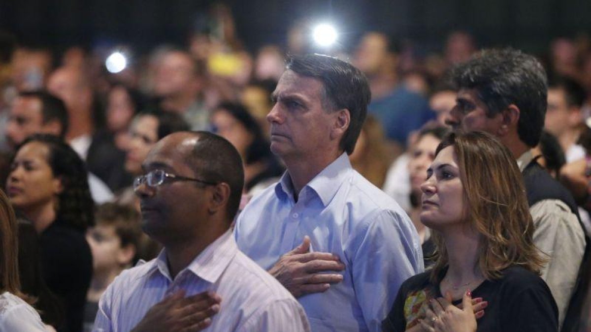 El presidente electo de Brasil  Jair Bolsonaro  y su esposa Michelle Bolsonaro  mientras participan en un culto evangelico.