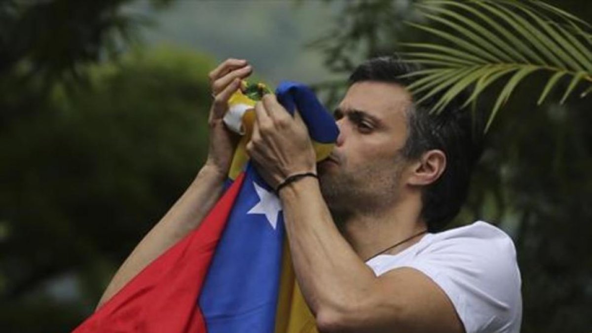 Leopoldo López besa la bandera venezolana tras ser liberado.