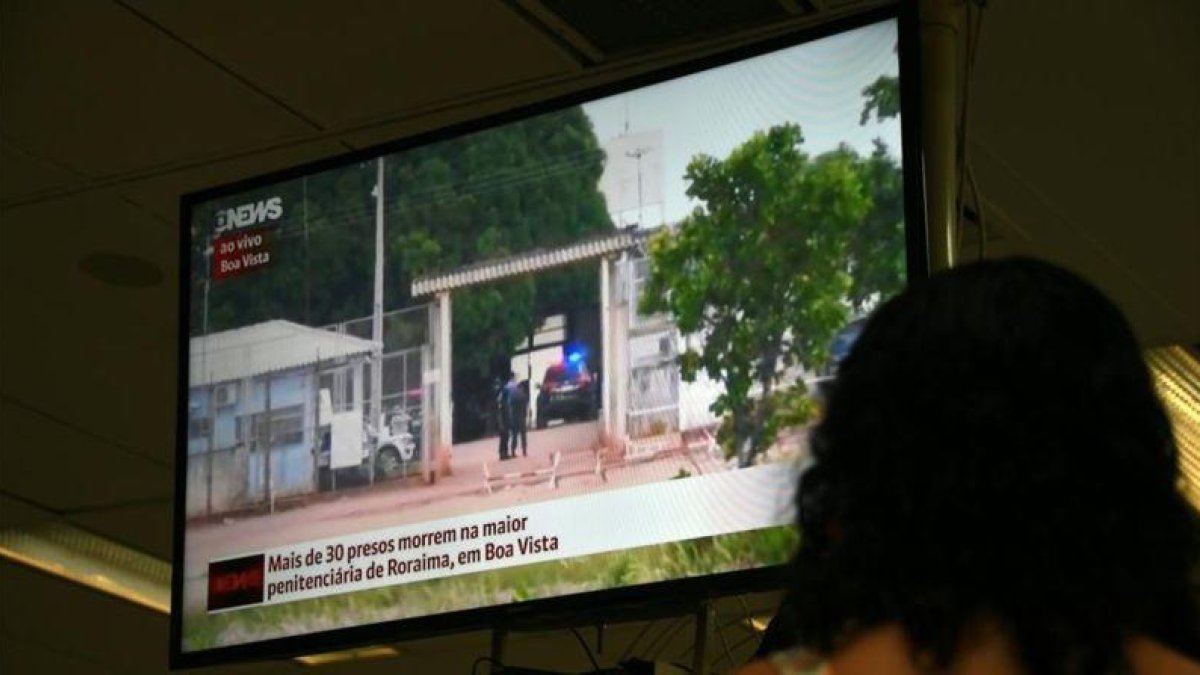 Una mujer sigue la noticia de la masacre en la prisión de Brasil a través de la televisión.