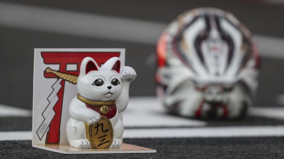 El gato que atrae a la suerte, junto al casco de Marc Márquez, en el box de Motegi en 2016.