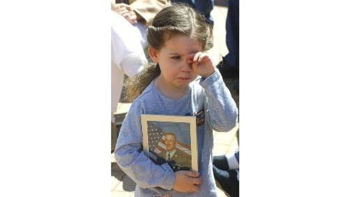 Elizabeth Heathman, de 4 años, muestra la foto de su padre, prisionero