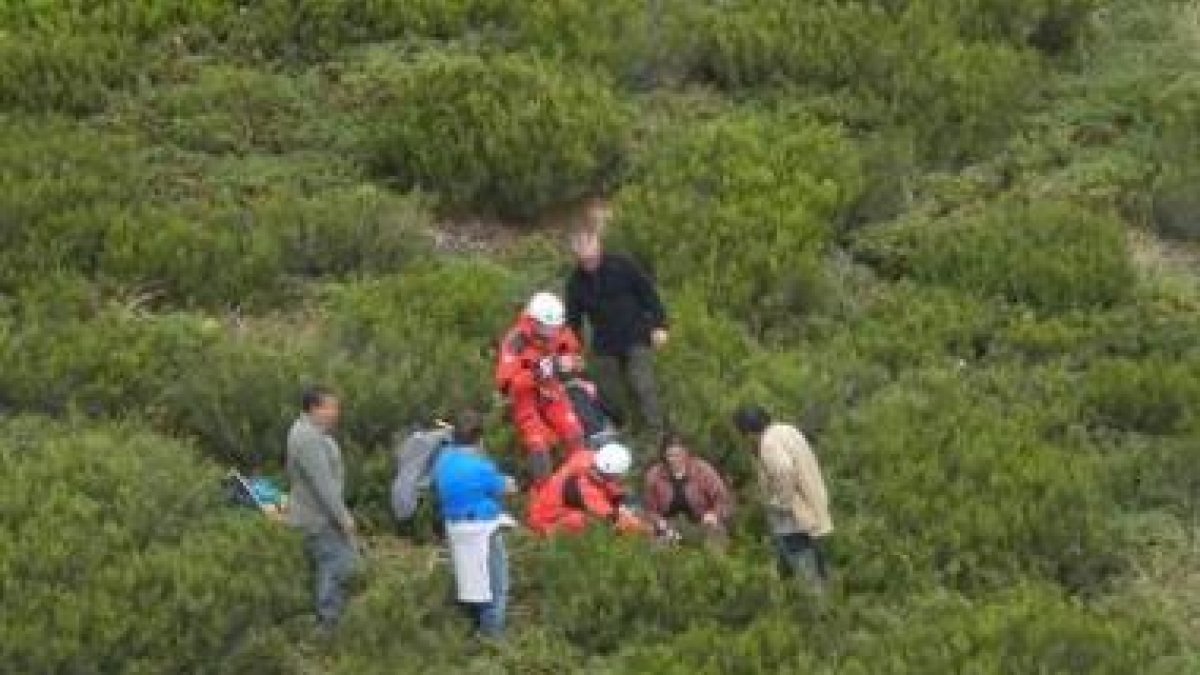 Los dos rescatadores (de rojo), ayer junto a la mujer herida y varios acompañantes.