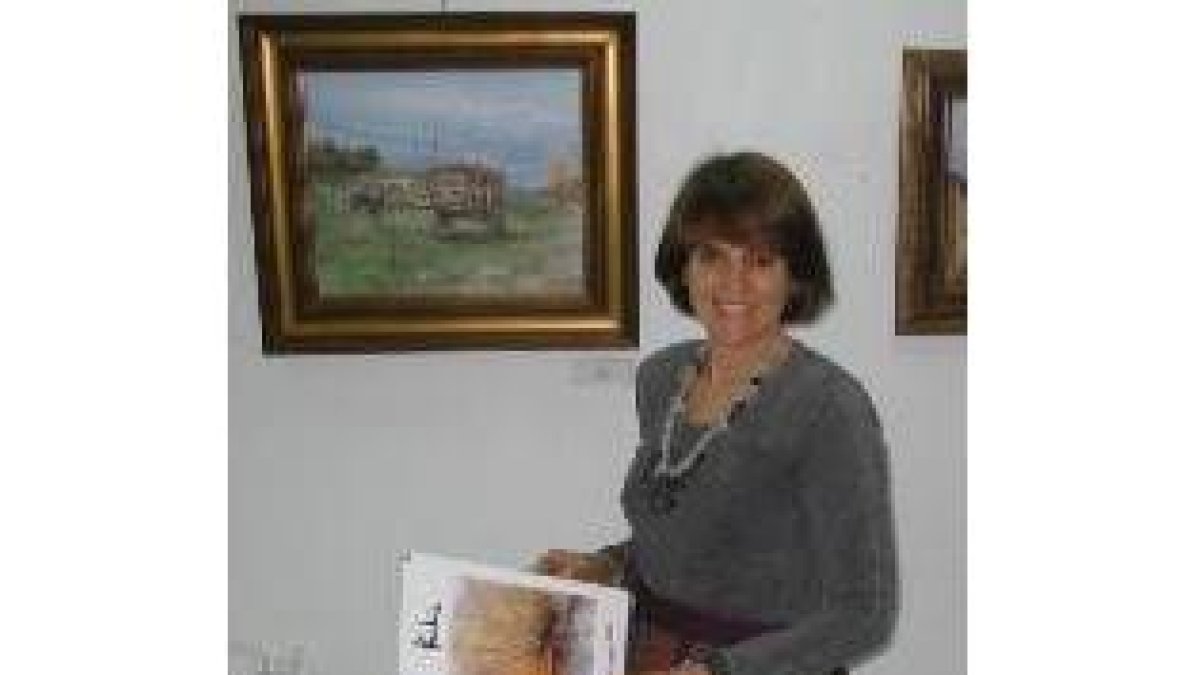 María Jesús López posa junto a uno de los cuadros expuestos