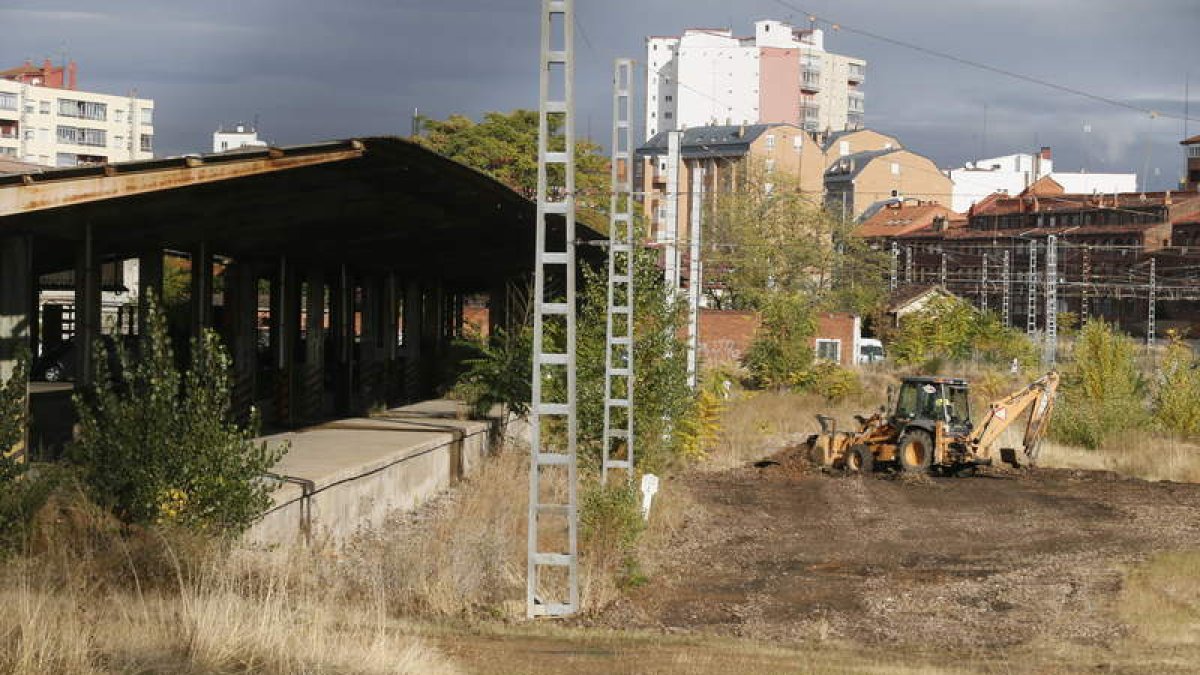 Los operarios y una máquina retroexcavadora, ayer, en la zona que se utilizará para el acopio de las obras de soterramiento. RAMIRO