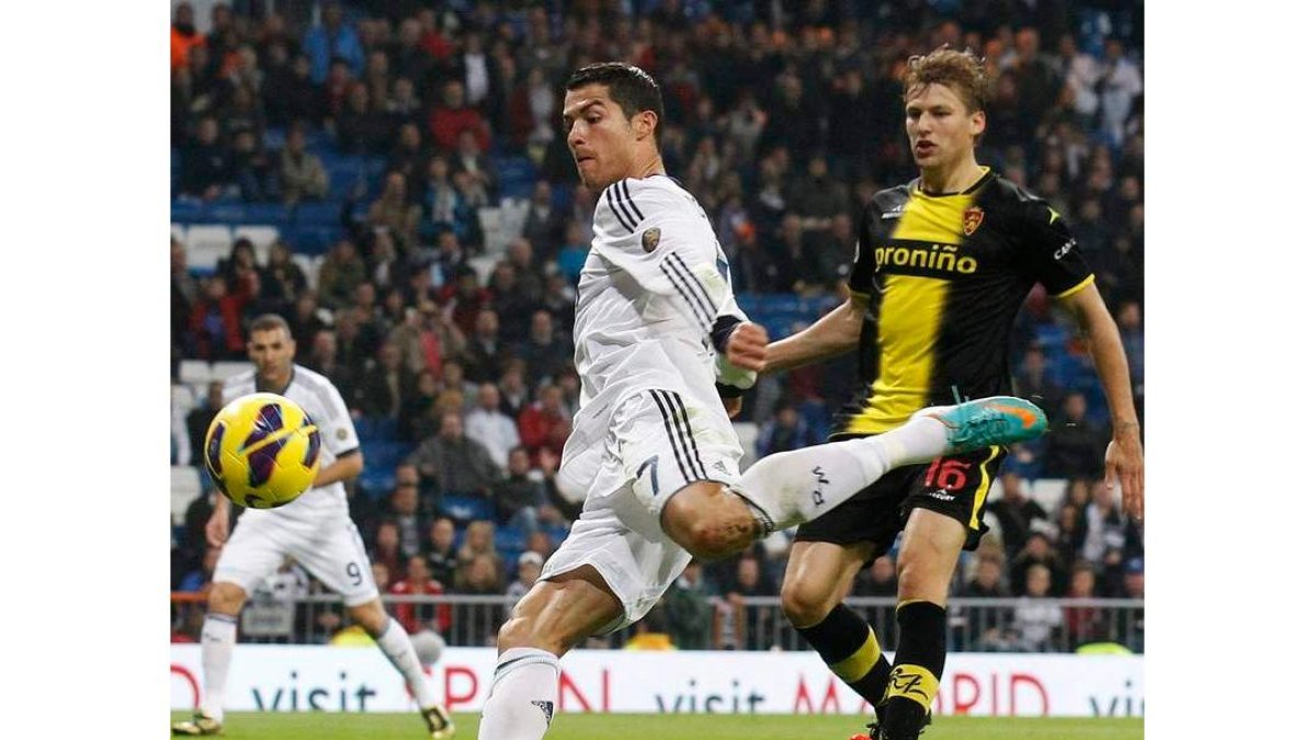 Cristiano Ronaldo golpea de volea el balón ante la atenta mirada del zaragocista Loovens.