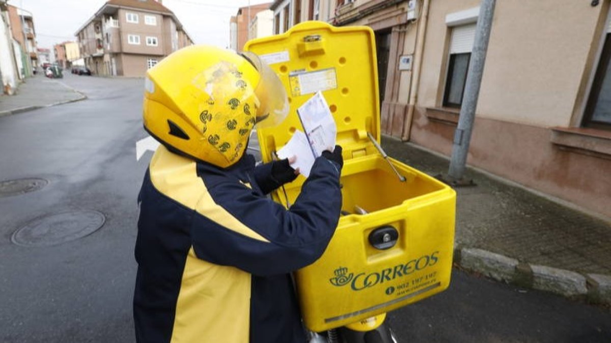 Una cartera de Correos en León revisa correspondencia. MARCIANO PÉREZ