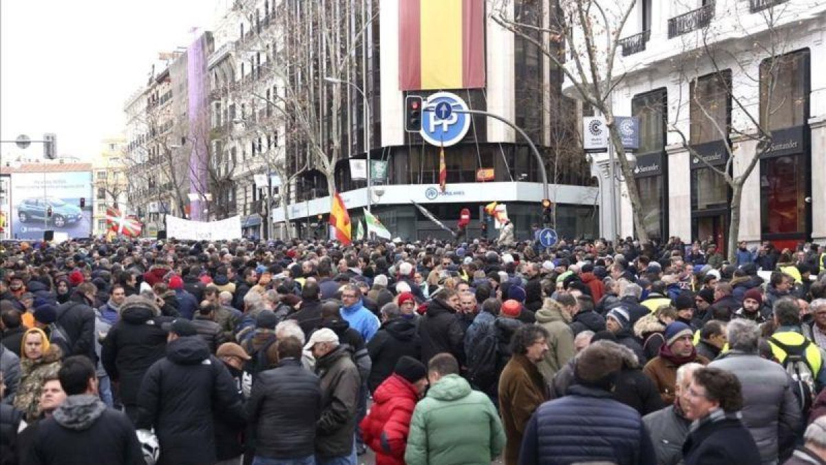 Los taxistas de Madrid se manifiestan frente a la sede del PP en la calle de Génova.
