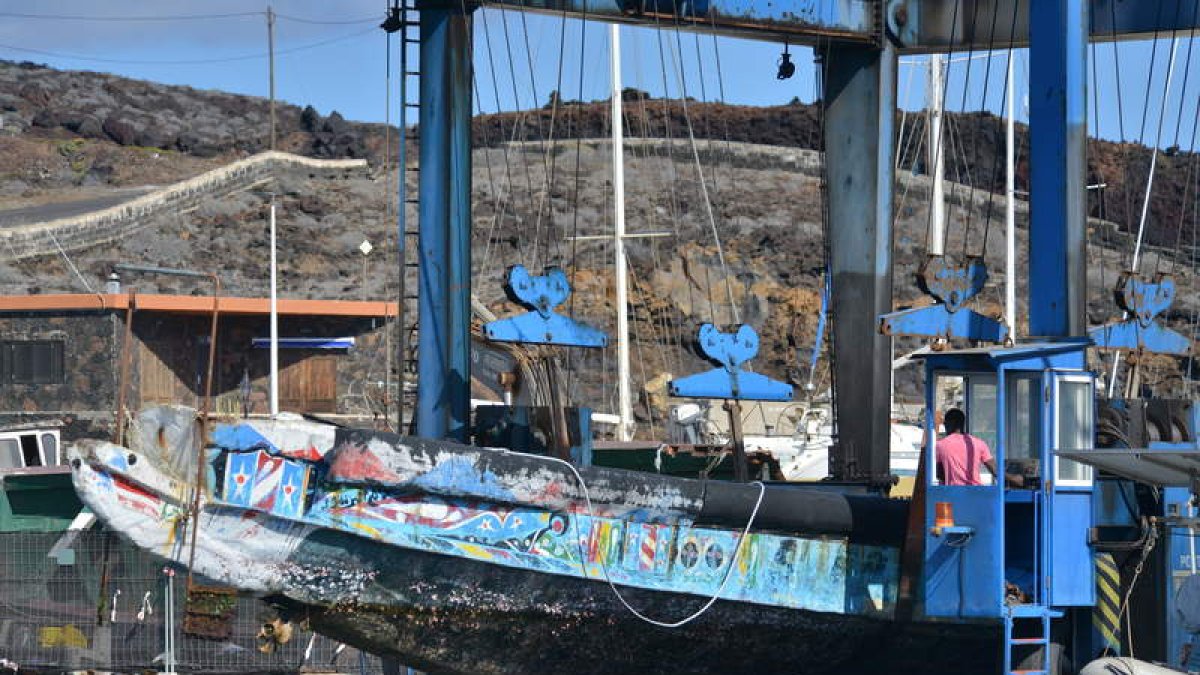 Varios operarios sacan del muelle de la Restinga los cayucos acumulados. GELMERT FINOL